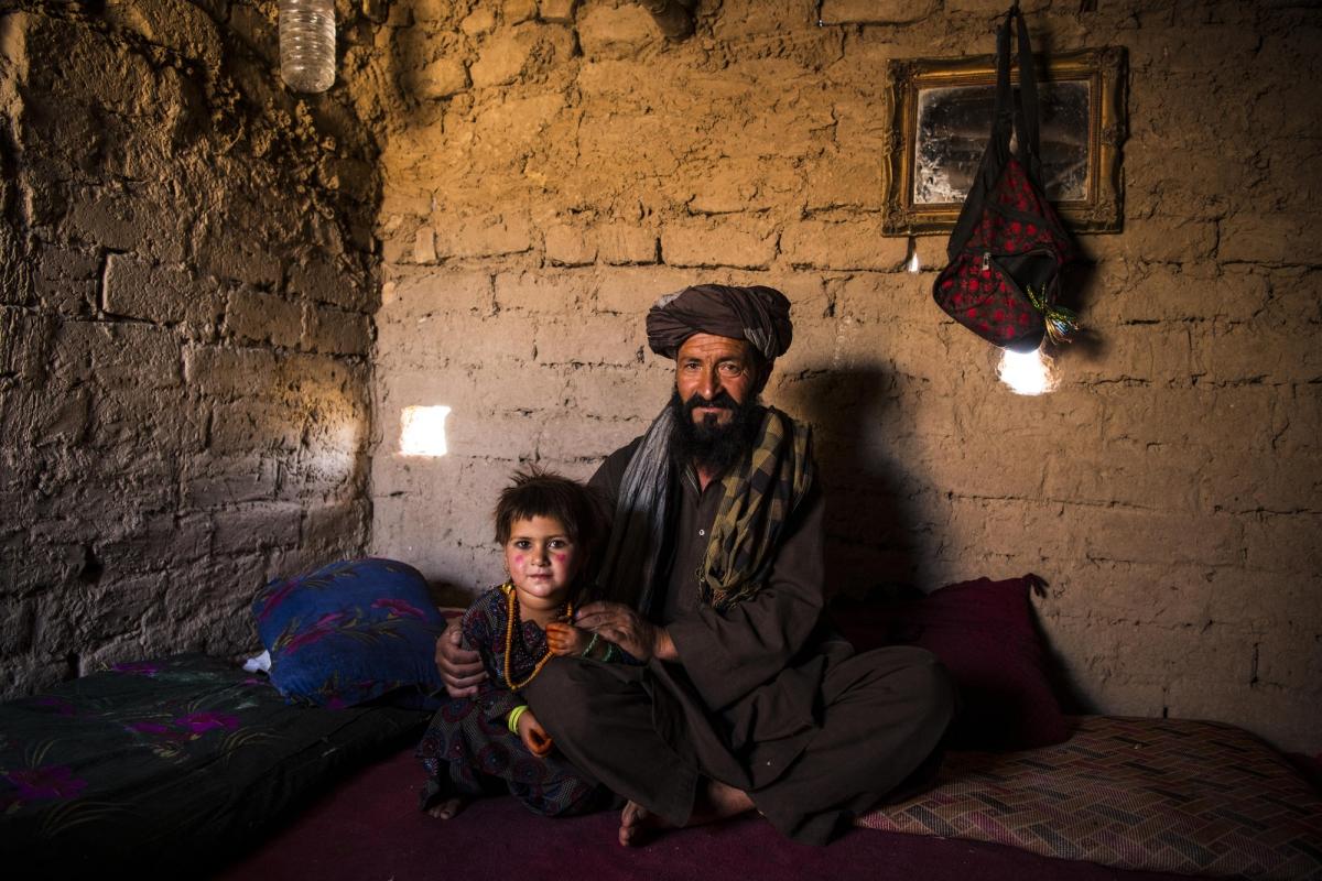 Camp de déplacés de Shahrak-é-Sabz, en périphérie de la ville d'Hérat, Afghanistan, août 2019. Bismillah et sa fille Najiba dans leur minuscule maison construite en briques de terre crue.
 © Andrew Quilty