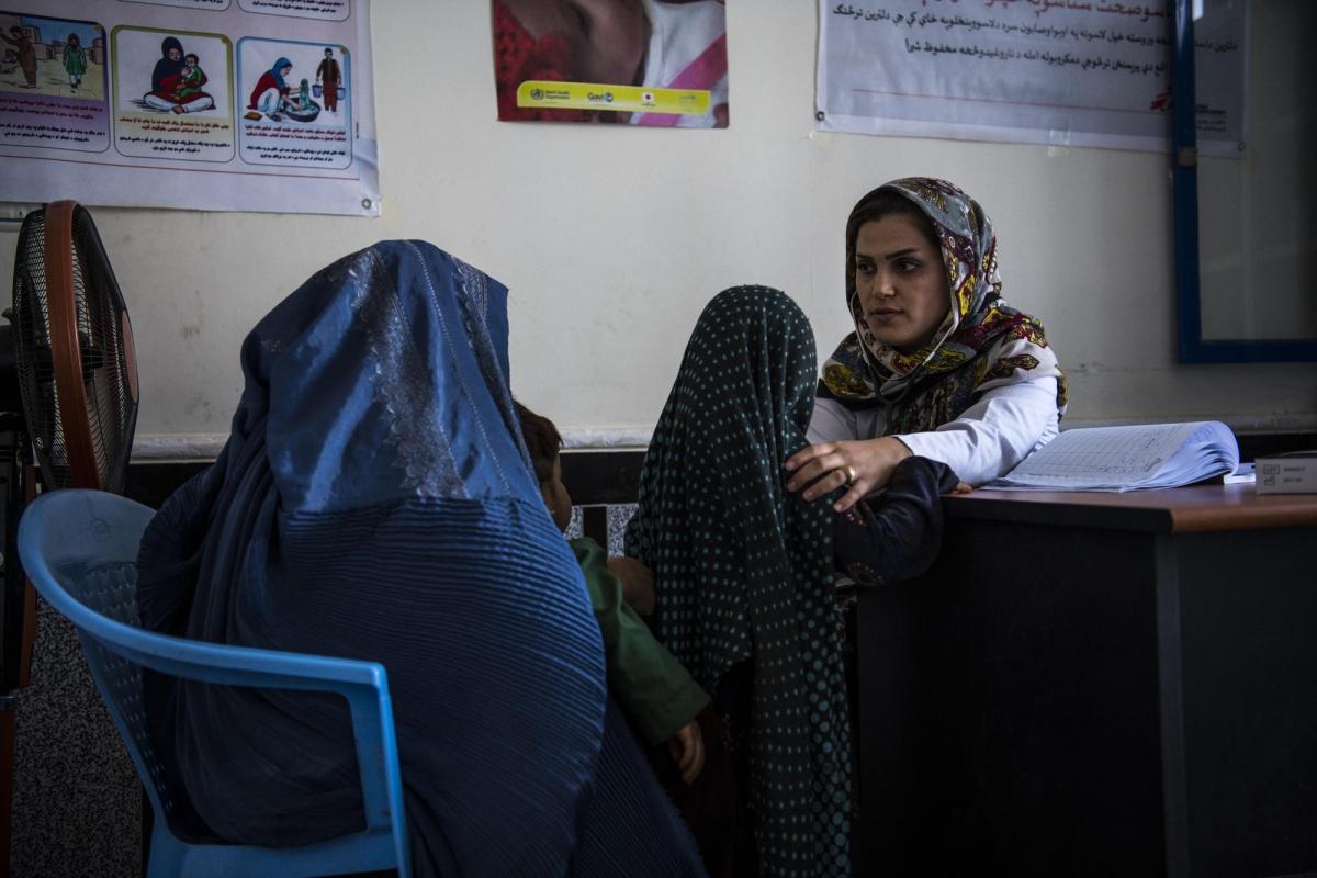 Clinique de santé de MSF en périphérie d'Hérat, Afghanistan, août 2019. La Dr. Azada Barez effectue une consultation auprès de jeunes patients.
 © Andrew Quilty