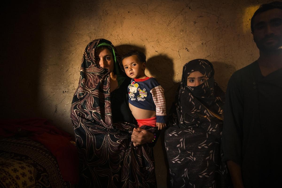 Camp de déplacés de Shahrak-é-Sabz, en périphérie de la ville d'Hérat, Afghanistan, août 2019. Portrait d'une famille à l'intérieur de leur maison.
 © Andrew Quilty