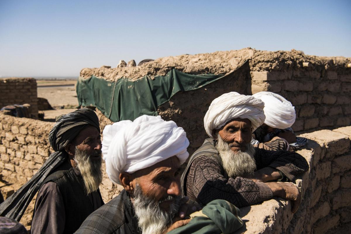 Camp de déplacés de Shahrak-é-Sabz, en périphérie de la ville d'Hérat, Afghanistan, août 2019. Des anciens se retrouvent pour observer la vie du camp.
© Andrew Quilty