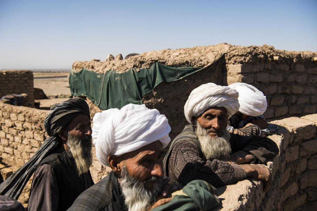 Camp de déplacés de Shahrak-é-Sabz, en périphérie de la ville d'Hérat, Afghanistan, août 2019. Des anciens se retrouvent pour observer la vie du camp.
 © Andrew Quilty