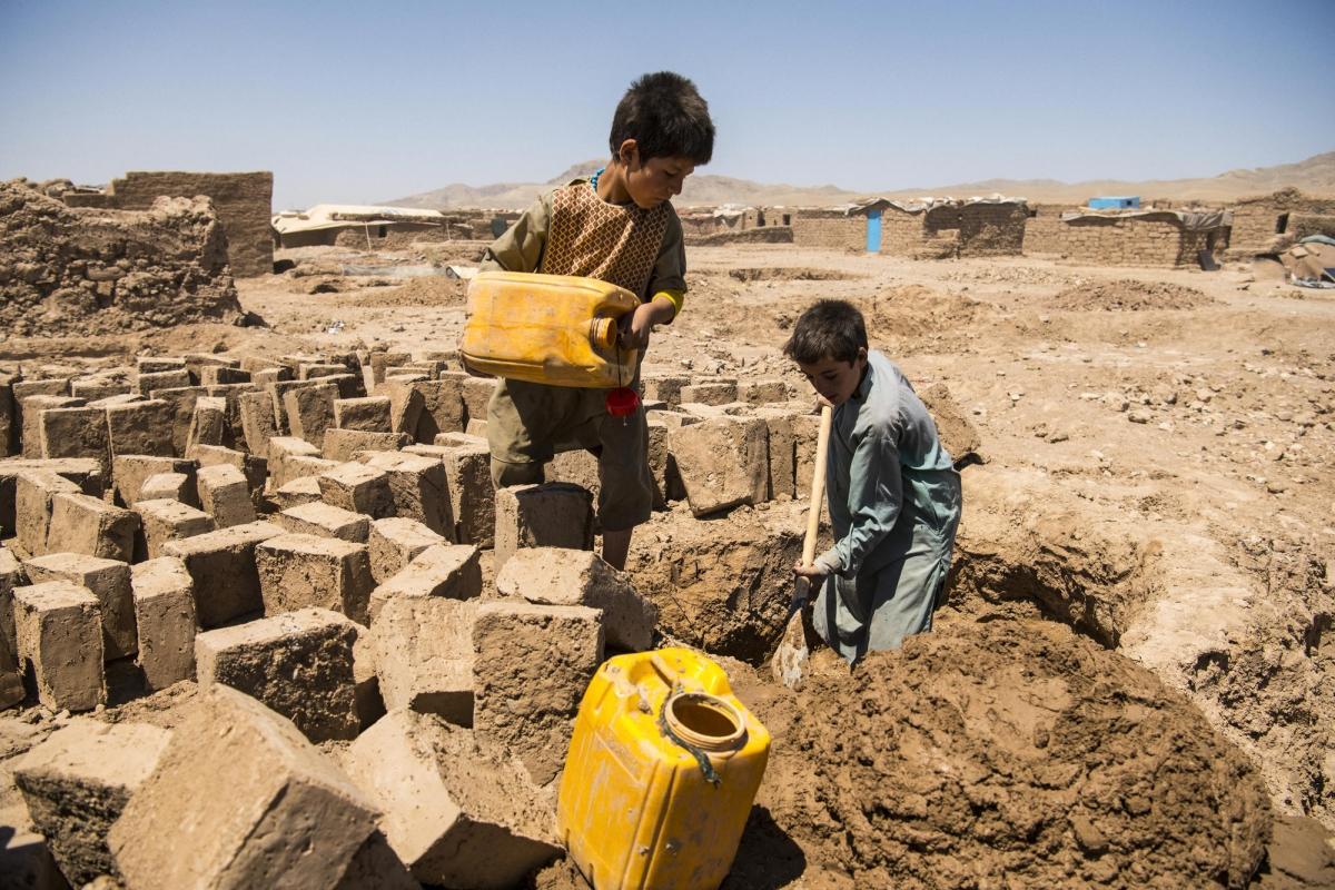 Camp de déplacés de Shahrak-é-Sabz, en périphérie de la ville d'Hérat, Afghanistan, août 2019. De jeunes garçons fabriquent des briques en terre crue.
© Andrew Quilty