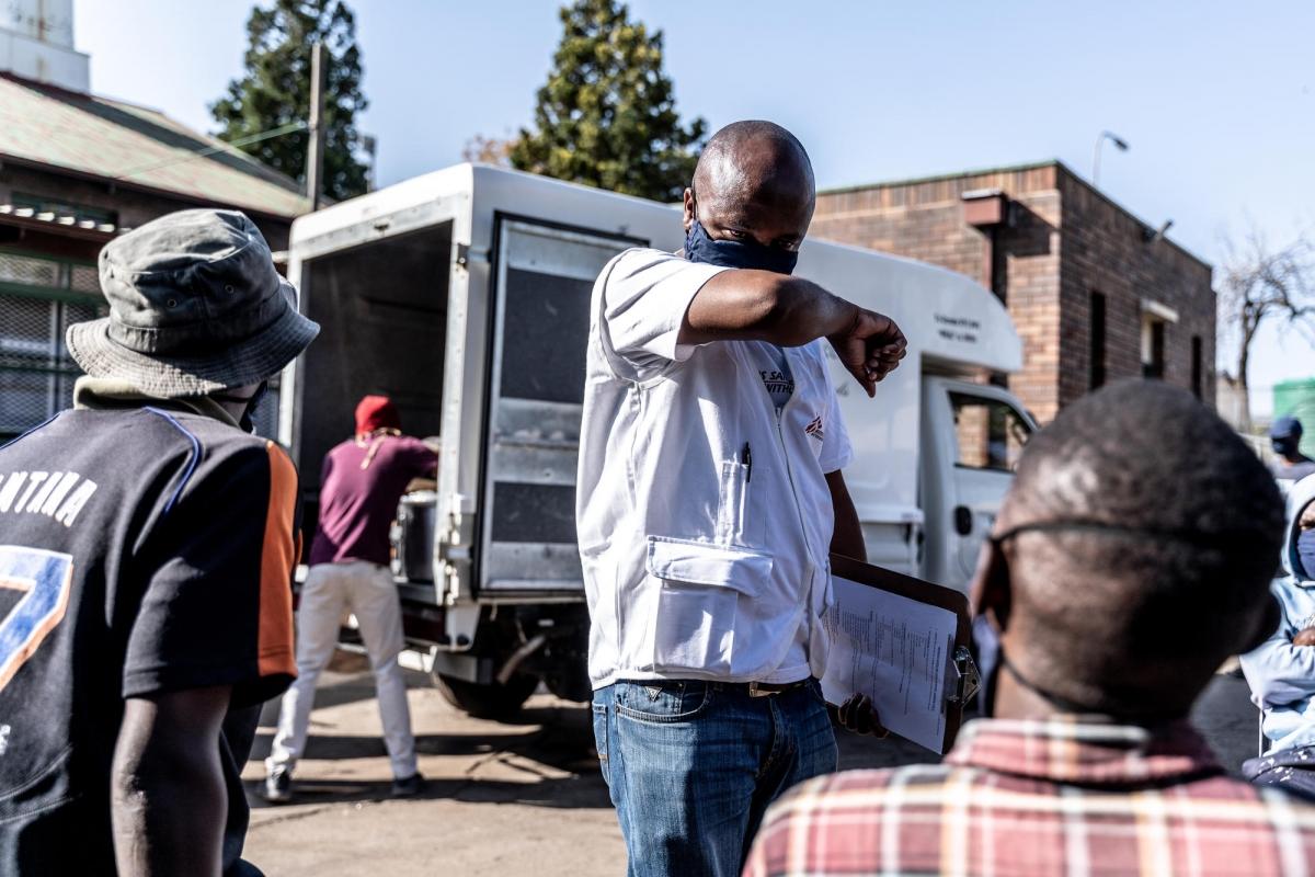 Un promoteur de la santé de MSF montre aux gens les bons gestes pour se protéger pendant la pandémie de Covid-19. Afrique du Sud.
 © Tadeu Andre/MSF