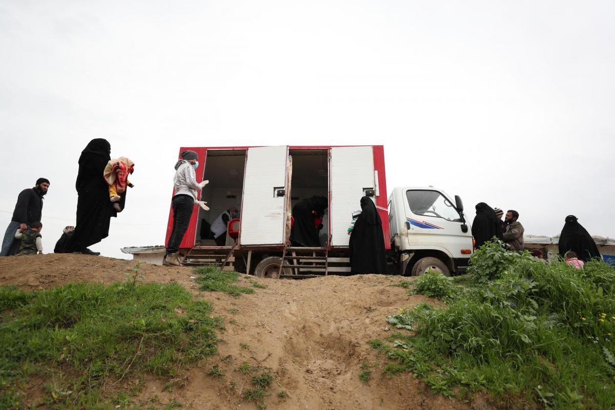 Des personnes attendent pour se faire soigner en respectant les mesures barrières de distanciation dans un camp du nord-ouest de la Syrie.
 © OMAR HAJ KADOUR/MSF