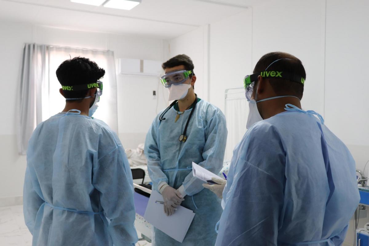 Le Dr Justin Dalby et l'équipe médicale du nouveau centre de traitement Covid-19 de MSF à Herat discutent de l'état des premiers patients admis le 28 juin 2020.
 © Laura Mc Andrew/MSF