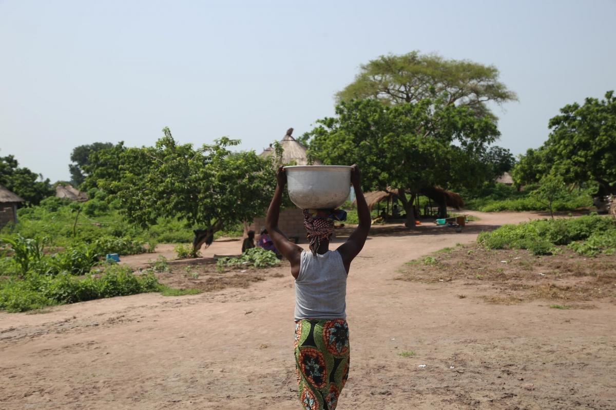 Une femme portant un seau sur la tête après l'avoir rempli à un point d'eau du site B pour les personnes déplacées de la ville de Kabo.
 © Igor Barbero/MSF