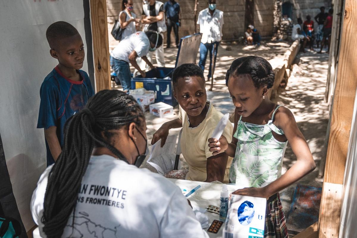 Annette et ses trois enfants en consultation avec un docteur MSF dans le cadre&nbsp;d'une clinique mobile installée au Parc Celtique, un site informel de personnes déplacées. Port-au-Prince. Haïti. 2021.
 © Pierre Fromentin/MSF