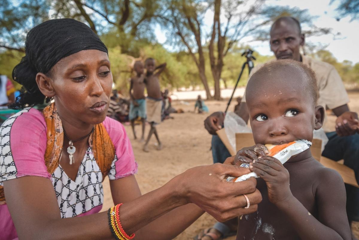 Fozia, une volontaire en santé communautaire, nourrit Murikow, âgé de deux ans, avec du plumpy nut, lors d'une intervention de proximité à Illeret. Murikow souffre de malnutrition aiguë modérée et son frère de malnutrition aiguë sévère.
 © MSF/Lucy Makori