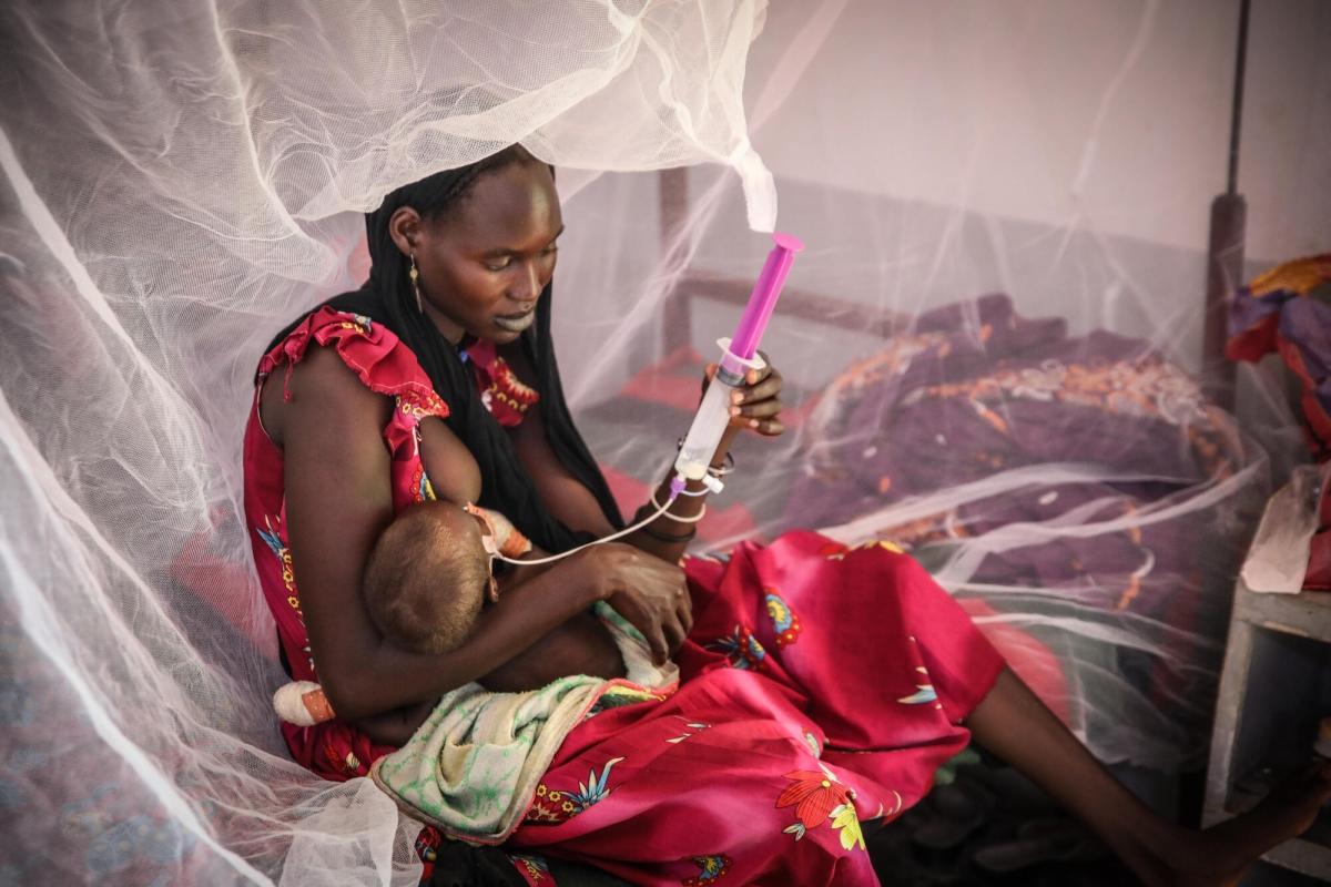 Portrait d'une mère en train de s'occuper de son enfant à l'hôpital d'Adré, où les équipes de MSF prennent en charge les enfants souffrant de malnutrition aiguë sévère. Tchad, août 2022.&nbsp;
 © Mohammad Ghannam/MSF