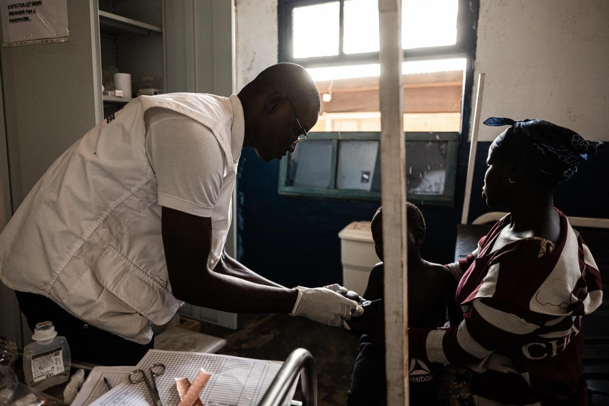 Un infirmier MSF réalise une injection sur un enfant qui souffre d'un forte fièvre. Hôpital de Drodro en Ituri. 2023.
 © MSF/Michel Lunanga