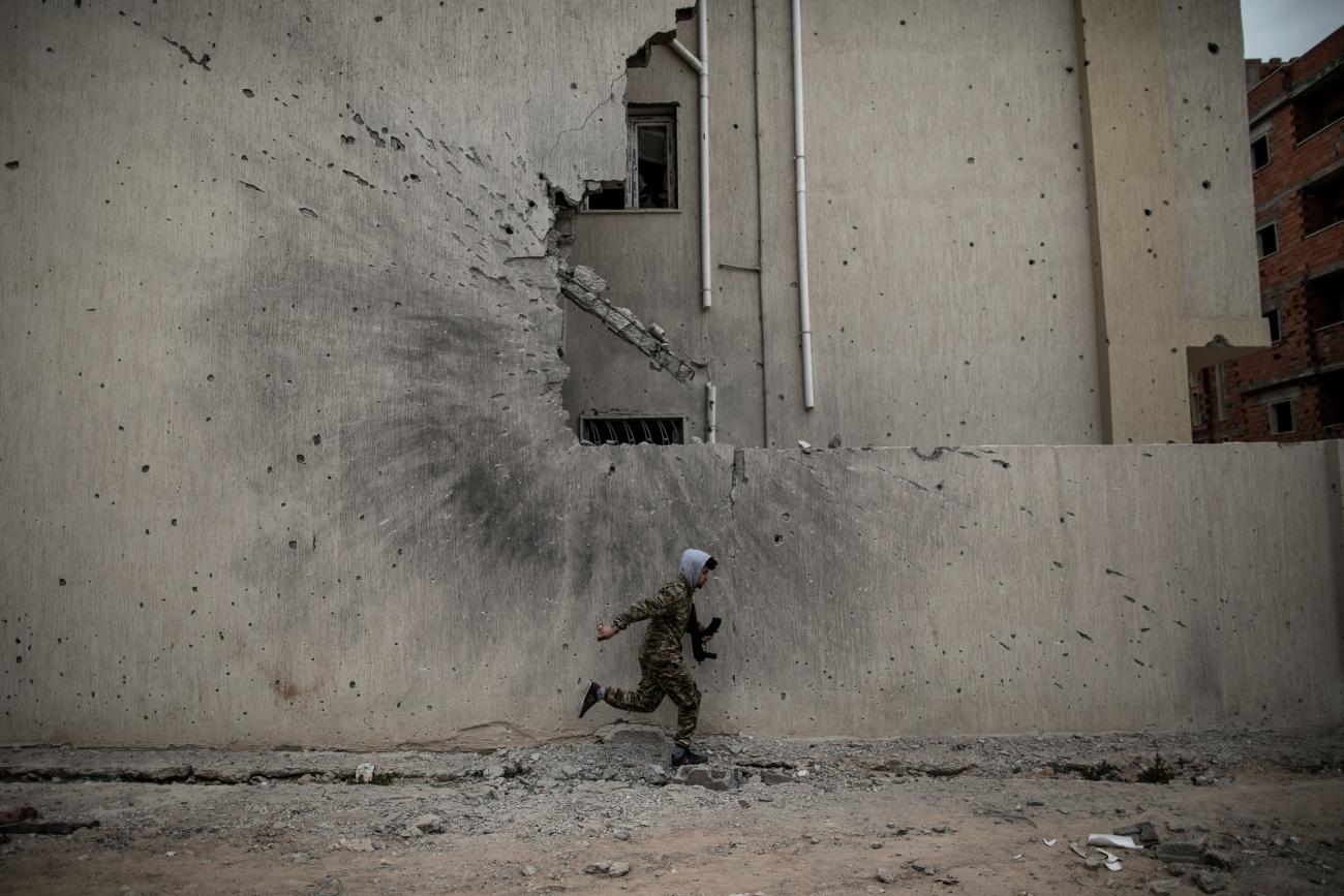Un combattant du gouvernement d'union nationale (GNA) se met à l'abri des tirs des snipers de l'Armée nationale libyenne (ANL) sur une ligne de front à Tripoli, le 17 février 2020. Ce jour là est symbolique. Il marque la date anniversaire de la révolution de 2011 qui a fait chuter le Guide Mouammar Kadhafi et mis fin à son régime. Depuis, la Libye, divisée en territoires rivaux avec plusieurs gouvernements se disputant le pouvoir et le contrôle de ses ressources, reste marquée par des épisodes de violents combats. Tripoli. 17 février 2020. ©Amru Salahuddien.
© Amru Salahuddien