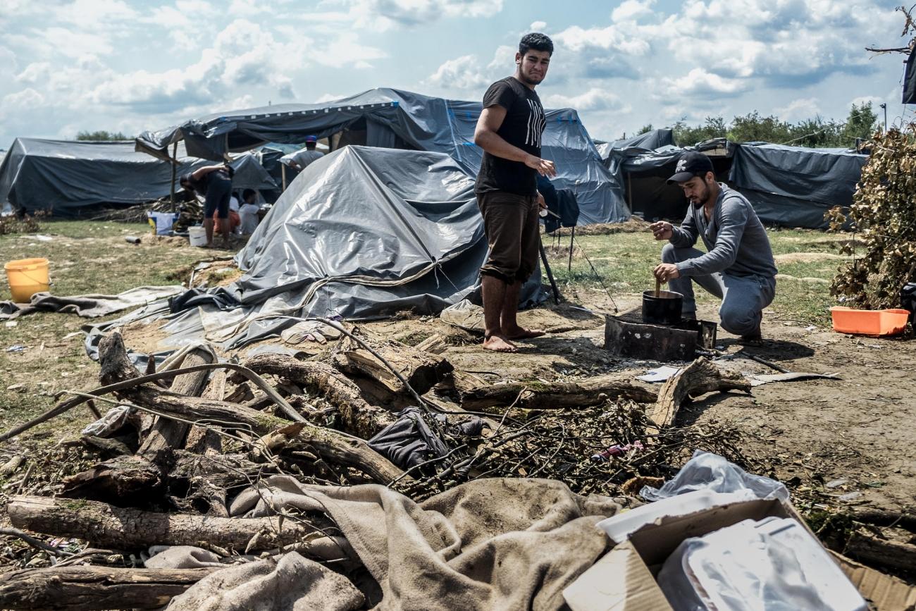 Deux hommes originaires de Syrie cuisinent avec des matériaux de récupération dans un camp informel près de Velika Kladuša. Bosnie-Herzégovine. 2018.
© Kamila Stepien