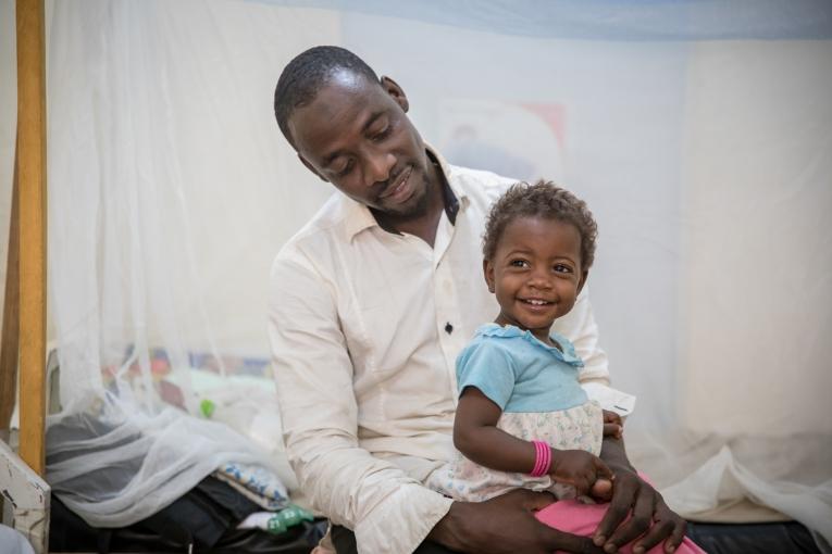 Mohammed Usseini et sa fille Oumi. Il y a plus d'un an, l'épouse de Mohammed a été blessée à l'épine dorsale, prise dans un feu croisé alors qu'elle tentait de fuir son village situé dans la zone rouge, au Nord-Est du Nigéria, pour chercher refuge au Cameroun.
© Pierre-Yves Bernard / MSF