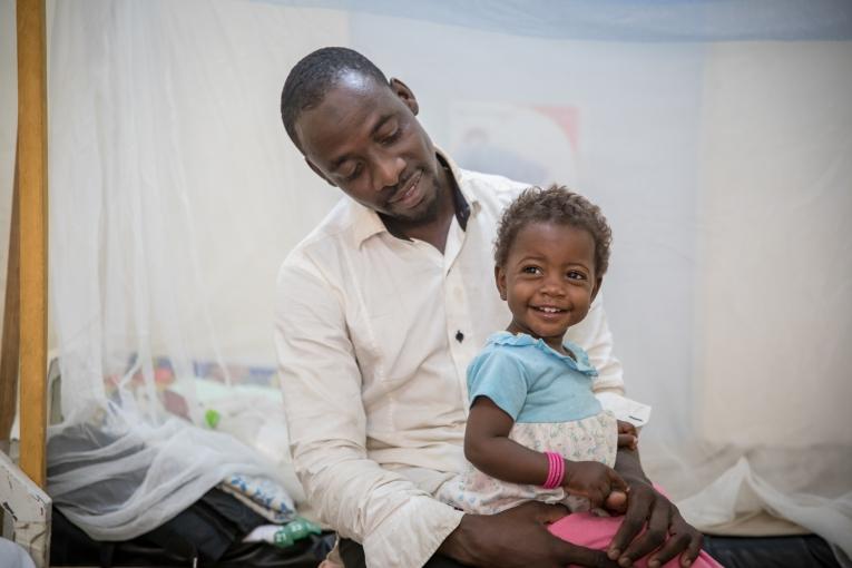 Mohammed Usseini et sa fille Oumi. Il y a plus d'un an, l'épouse de Mohammed a été blessée à l'épine dorsale, prise dans un feu croisé alors qu'elle tentait de fuir son village situé dans la zone rouge, au Nord-Est du Nigéria, pour chercher refuge au Cameroun.
 © Pierre-Yves Bernard / MSF