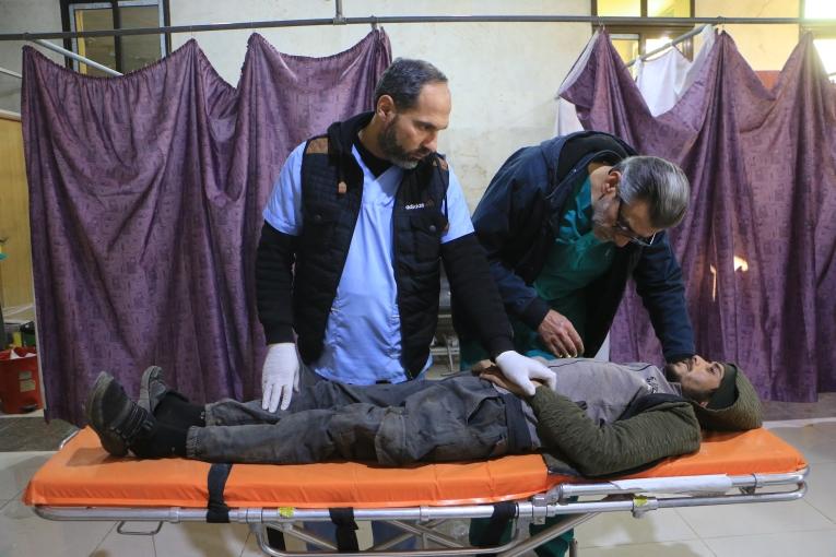 Le Dr Samih Kaddour (à gauche), accompagné d'un infirmier, en consultation avec un patient victime des tremblements de terre, le 11 février dans l'hôpital d'Aqrabat soutenu par MSF. Nord-ouest de la Syrie.
 © Abdul Majeed Al Qareh