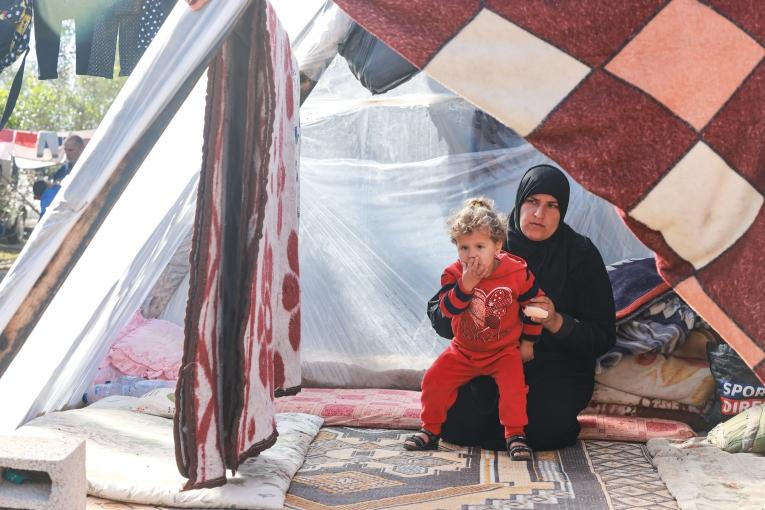 Yasmine avec l'un de ces cinq enfants sous une tente à Rafah.&nbsp;
 © Mohammad Abed