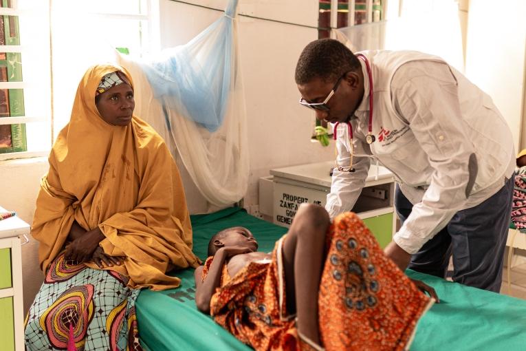 Awalu Bilya (11 ans) est allongé aux côtés de sa mère, Rekiya Usman, tandis que le Dr Abdulrahman Muhammad, de MSF, l'examine dans le service de chirurgie de l'hôpital général de Zurmi, dans l'État de Zamfara, au Nigeria. 31 mars 2026.
 © Nnoli Amarachi