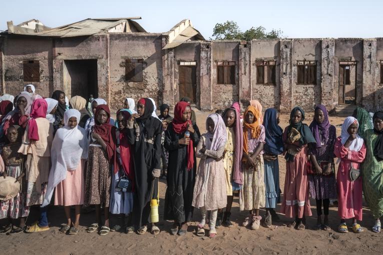 In El Geneina, children gather in lines at the start of the school day at the destroyed Al Kasim Primary School. Before the war broke out in April 2023, the facility housed a site for displaced persons. It subsequently became the target of violent attacks. In early January 2024, classes resumed amidst the ruins for 652 children, including displaced persons and local children. As no meals are provided, the school day ends at noon – two hours earlier than usual. 20 February 2024.
 © Diana Zeyneb Alhindawi