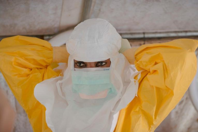 Un membre du personnel MSF revêt l'équipement de protection individuelle pour entrer dans une zone à haut risque et offrir des soins de santé à des patients atteints par Ebola, dans l'hôpital de Donka à Conakry. Guinée. 2015.