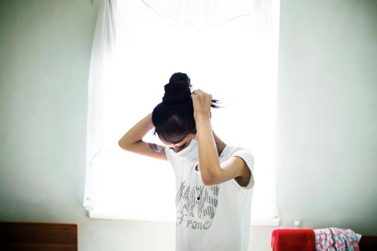 Une jeune femme affectée par la tuberculose multirésistante se prépare pour la journée à l'hôpital de Och, soutenu par Médecins Sans Frontières. Kirghizistan. 2017.