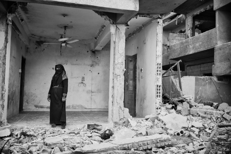 Une femme regarde ce qui a été un jour sa maison, en ruine après les offensives sur Rakka.
© Eddy Van Wessel