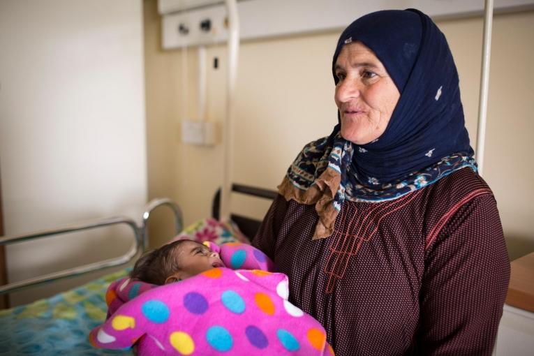 La famille du petit Mohamed, dans les bras de sa grand-mère, devait emprunter de l’argent auprès de ses&nbsp;proches pour pouvoir payer chaque visite à l’hôpital, jusqu’au jour où on leur a parlé d’un service de pédiatrie géré par MSF qui fournissait des services de santé gratuits.
 © Florian SERIEX/MSF