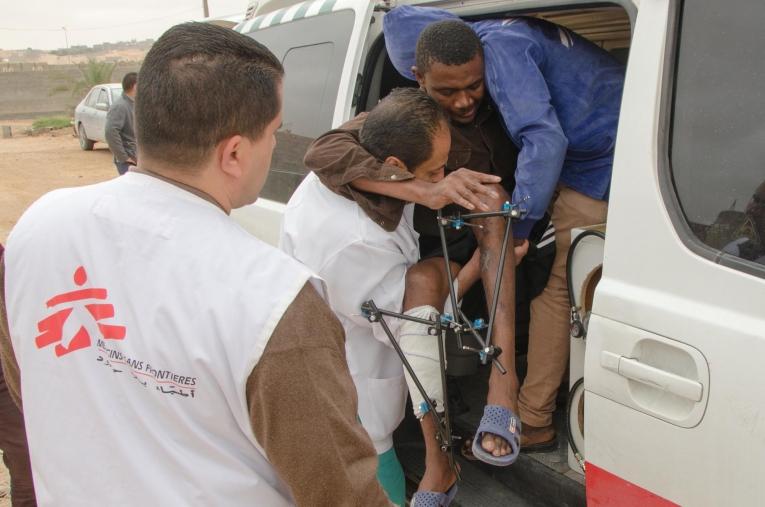 L’équipe médicale MSF réfère un patient depuis Bani Walid vers une structure de soins secondaires. Il est suivi depuis plusieurs semaines et souffre de fractures multiples aux deux jambes. La très grande majorité des patients pris en charge à Bani Walid ont réchappé de prisons clandestines présentes dans la région. Ils ont été kidnappés, torturés&nbsp;et retenus captifs par des réseaux criminels qui leur font vivre un calvaire pour obtenir d’eux une rançon. Ces rescapés sont profondément affaiblis, avec des plaies qui se sont infectées, et de multiples traumatismes.&nbsp;
 © Christophe Biteau/MSF