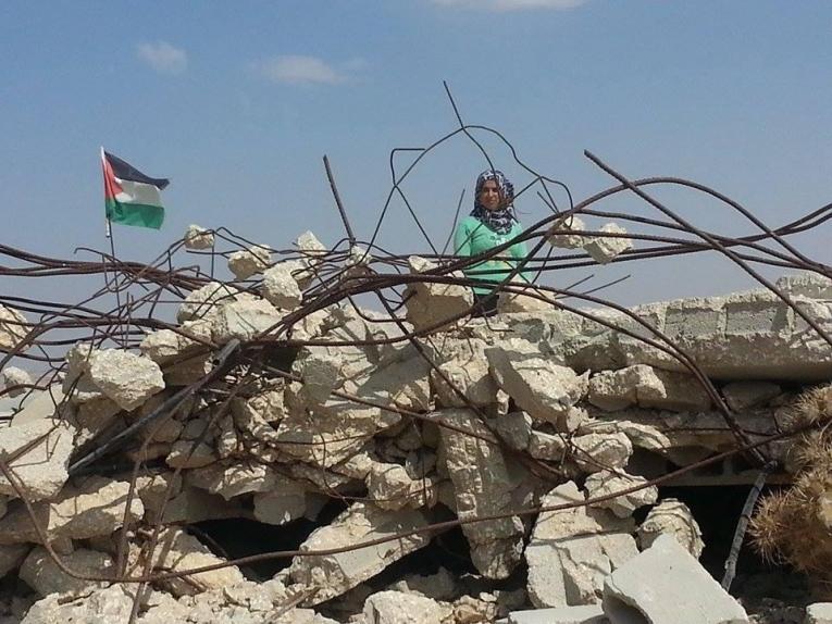 Une jeune femme palestinienne se tient devant les restes de sa maison détruite à Hébron. 2014.
 © Muwaffaq Joulani/MSF