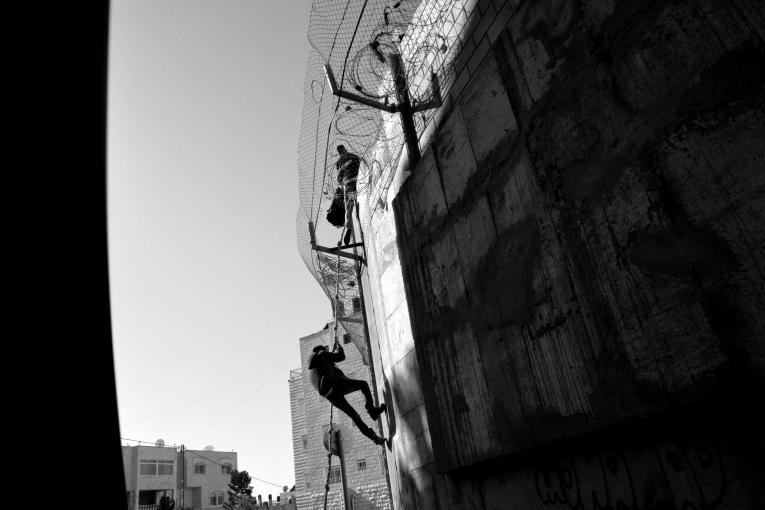 Des palestiniens rentrent à Jérusalem-Est en escaladant le mur pour éviter la longue attente au checkpoint. 2014.
&nbsp;
 © Aurelie Baumel/MSF