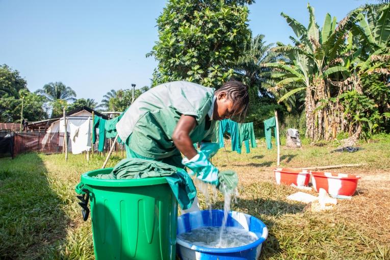 Un membre de l'équipe d'hygiène de MSF lave les blouses désinfectées dans le centre de traitement d'Ebola de MSF à Bikoro, en RDC.
 © Louise Annaud/MSF