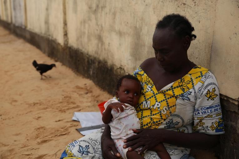 Demba tient son petits-fils dans ses bras. Le garçon de 6 mois commence à aller mieux après 5 jours d'hospitalisation dans le centre nutritionnel thérapeutique de MSF. Tchad. 2018.
© Mohammad Ghannam/MSF
