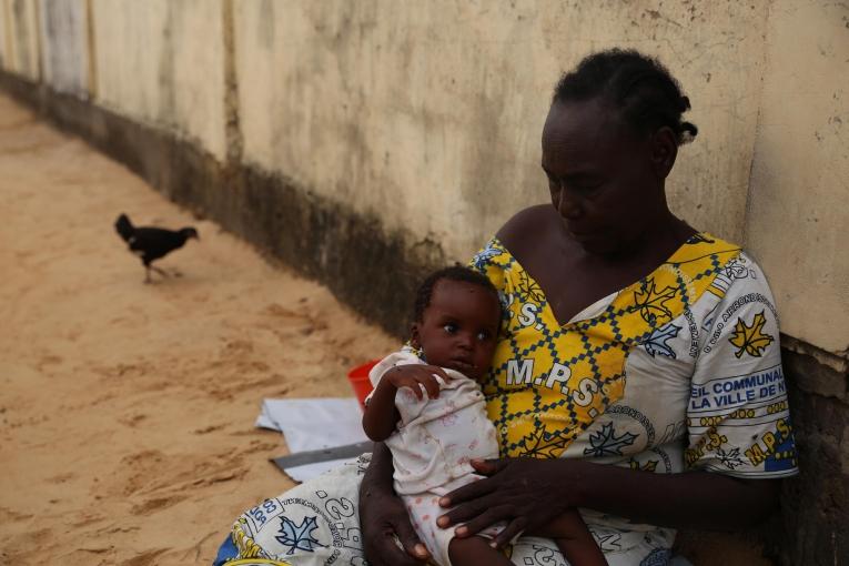 Demba tient son petits-fils dans ses bras. Le garçon de 6 mois commence à aller mieux après 5 jours d'hospitalisation dans le centre nutritionnel thérapeutique de MSF. Tchad. 2018.
 © Mohammad Ghannam/MSF