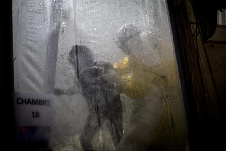 Un travailleur de santé MSF accompagne une patiente Ebola dans son lit du centre de traitement de Butembo. Novembre 2018. République démocratique du Congo.
© John Wessels