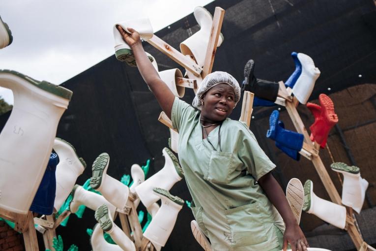 Une travailleuse de santé MSF met à sécher les chaussures désinfectées des équipes du centre de traitement Ebola de Butembo. Novembre 2018. République démocratique du Congo.
 © Alexis Huguet