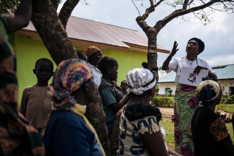 En marge des activités de décontamination d'un hôpital, une travailleuse de santé MSF sensibilise les personnes présentes à l'importance du dépistage Ebola. Novembre 2018. République démocratique du Congo.
© Alexis Huguet