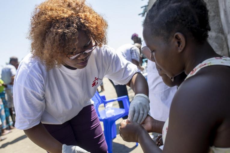 Rosa Afonso explique à une patiente comment suivre son traitement, prescrit par la clinique mobile de MSF. Beira, Mozambique, 26 mars 2019.
© Pablo Garrigos/MSF