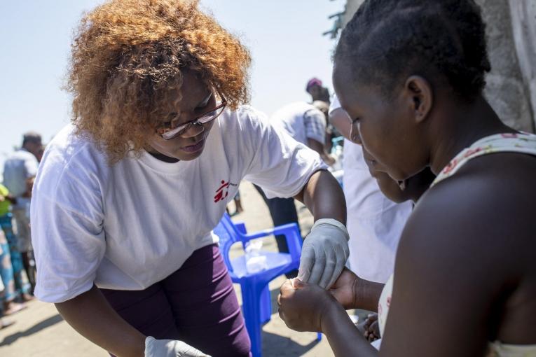 Rosa Afonso explique à une patiente comment suivre son traitement, prescrit par la clinique mobile de MSF. Beira, Mozambique, 26 mars 2019.
 © Pablo Garrigos/MSF