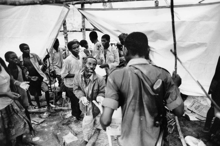 Réfugiés rwandais hutus au Zaïre. Désespérés, certains&nbsp;commencent à piller les stocks alimentaires du Programme alimentaire mondial. Des soldats rebelles tentent de mettre fin au pillage. 1997.&nbsp;
 © Kadir Van Lohuizen/Noor