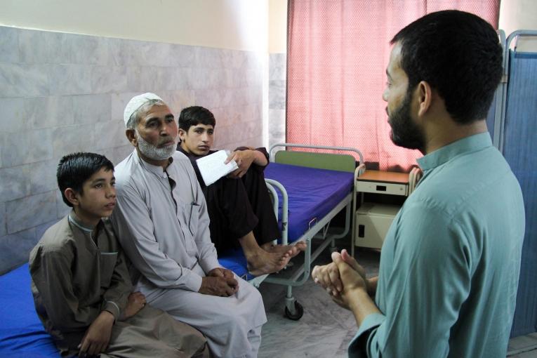 Muhammad Jannat et ses deux fils lors d'une séance de sensibilisation avec un promoteur de santé dans le centre de traitement MSF de Peshawar. 2019. Pakistan.&nbsp;
 © Nasir Ghafoor/MSF