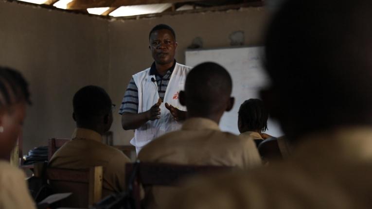 Abraham S. Kollie, un travailleur psychosocial MSF, parle à des étudiants de l'épilepsie. Les enfants épileptiques sont parfois exclus de l'école en raison de la stigmatisation sociale.
 © Armelle Loiseau/MSF