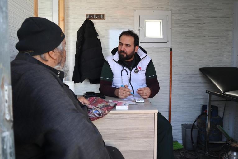 Le 17 février, un déplacé syrien s'entretient avec un médecin lors d'une consultation à la clinique mobile MSF du camp de Qadimoon, au nord-ouest de la Syrie.
 © MSF