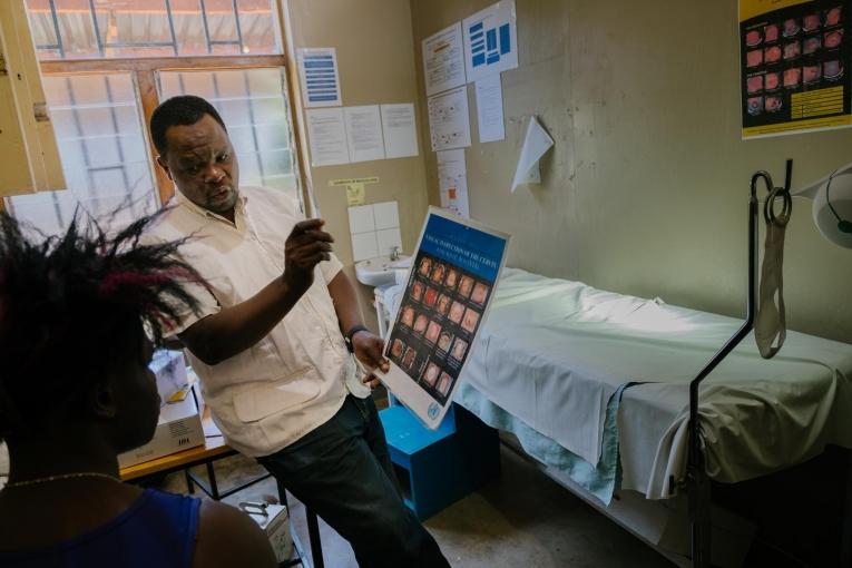 Prince Nkhoma explique le processus de dépistage du cancer du col de l'utérus à une jeune femme de 22 ans dans un dispensaire MSF pour les professionnel.le.s du sexe, intégré à l'hôpital de district de Mwanza. Le risque de développer un cancer du col de l'utérus est particulièrement élevé chez les professionnel.le.s du sexe : une mauvaise utilisation du préservatif et de multiples partenaires sexuels entraînent une transmission plus élevée du virus HP (HPV), qui provoque le cancer du col. Malawi.
© Isabel Corthier