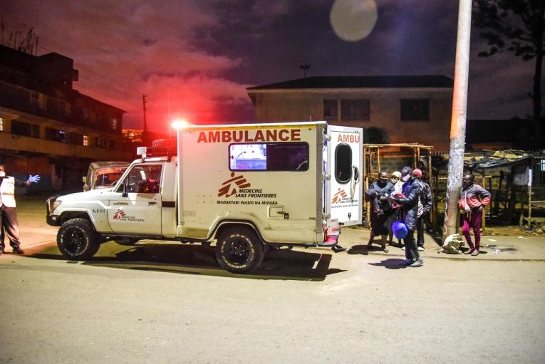 Les proches d'une femme devant une ambulance MSF pendant que l'équipe médicale procède à des tests préliminaires avant d'amener la patiente à l'hôpital
© Paul Odongo/MSF