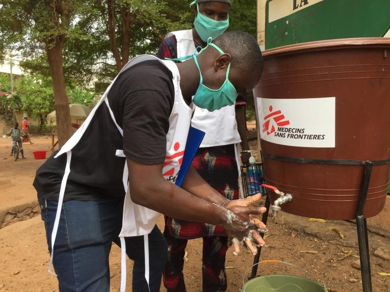 Nouhoum Diakité, infirmier MSF, montre les bons gestes pour un lavage de mains efficace, avec du savon et de l’eau propre, aux habitants du quartier Faladjè, à Bamako, où des cas positifs ont été déclarés.
 © Lamine Keita/MSF