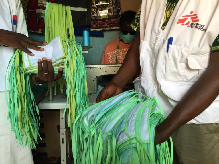 Lassi et Kebé, deux agents MSF, en visite dans l'atelier de couture où sont fabriqués les masques lavables, dans le quartier de Magnabougou, à Bamako.
 © Lamine Keita/MSF