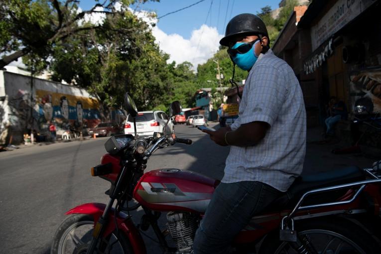 Alberto Martínez, 35 ans, attend des clients sur son mototaxi à Petare, dans l’agglomération de Caracas. Récemment, quand son fils de quatre ans, asthmatique, a eu besoin d’une assistance médicale, Alberto n’a pas trouvé la moindre structure médicale accueillant des patients atteints de pathologies autres que la Covid-19.
 © Carlos Becerra/MSF