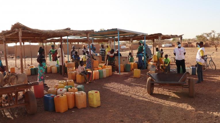 Des femmes et des enfants remplissent leurs jerricans avec de l'eau propre, dans un puits réhabilité de la ville de Titao. Février 2021. Burkina Faso.&nbsp;
 © Noelie Sawadogo/MSF