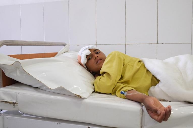 Samiullah, 12 ans, a été blessé par balle à la tête le 4 mai. Sa famille a dû traverser des jardins et une rivière, voyageant pendant deux heures et demie pour éviter les combats avant d'arriver à l'hôpital Boost.
 © MSF/Tom Casey