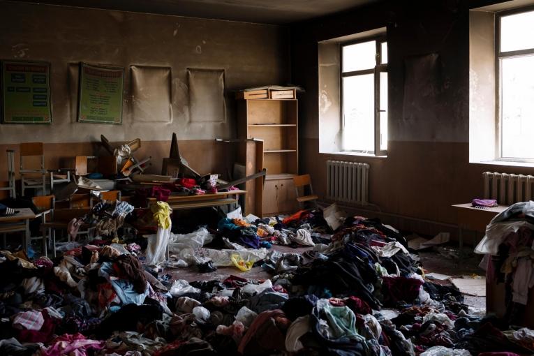 À l'intérieur de l'école incendiée de Maksat. Des tonnes d'aide humanitaire ont été envoyées par des personnes solidaires de Bichkek à Batken. Parmi cette aide, beaucoup de vêtements ne pouvaient pas être portés par les locaux car jugés trop légers selon les coutumes conservatrices du sud. Ils ont été jetés dans une salle de classe incendiée.

&nbsp;
 © Maxime Fossat