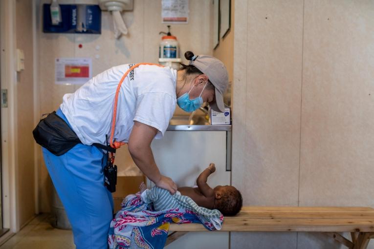 Marina Kojima, sage femme MSF, ausculte Bienvenu*, âgé de 6 semaines, à bord du Geo Barents.
 © Pablo Garrigos/MSF